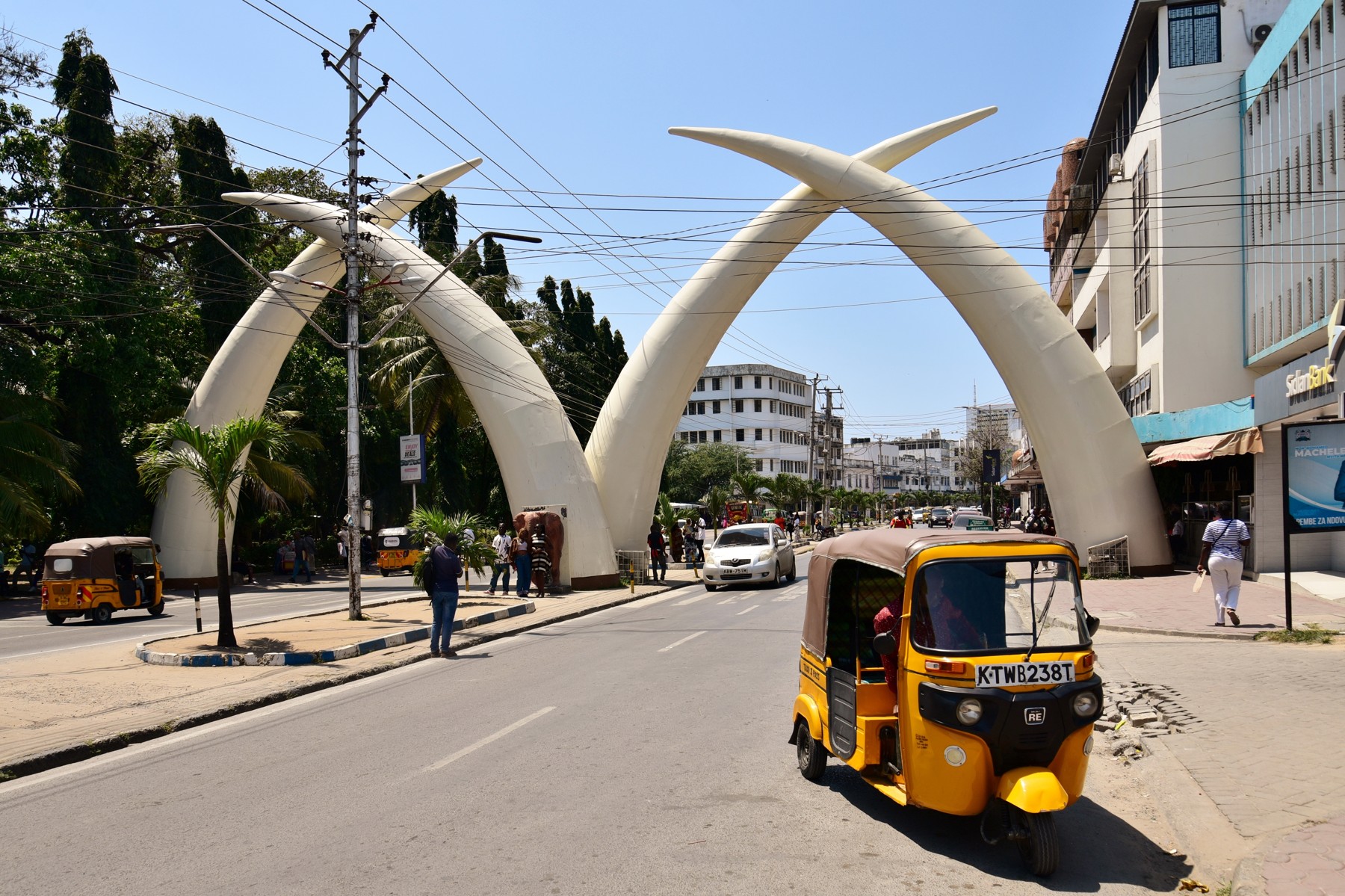 Mombasa Tusks with a yellow tuk-tuk passing under